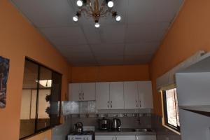 a kitchen with white cabinets and a ceiling at saga andina in Cusco