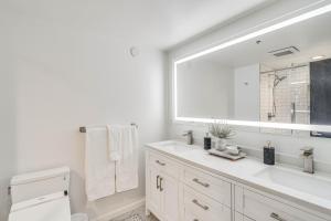 a white bathroom with a sink and a large mirror at Downtown Winter Park Condo with Free Bus to Ski Base in Winter Park +20 photos