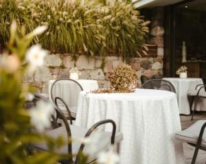 una mesa con un mantel blanco y flores en ella en Hotel Villa Freiheim en Merano