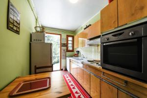 cocina con armarios de madera y microondas negro en Appartement 2 pièces 6 personnes avec superbe vue - maeva Home 82240, en Font-Romeu-Odeillo-Via