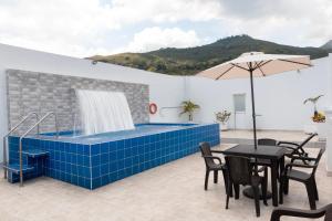 a hot tub on a patio with a table and chairs at Hotel Granada Real in Cali