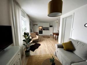 - un salon avec un canapé et une table dans l'établissement Kuscheliges Apartment am Limes, à Rainau