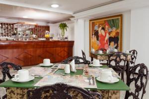 a dining room with a green table and chairs at Hotel Granada Real in Cali