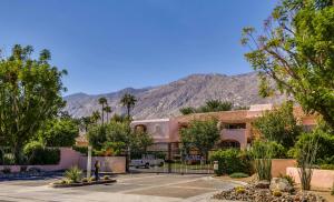 a home in the desert with mountains in the background at Chic Downtown Bungalow - A Ryson Property in Palm Springs