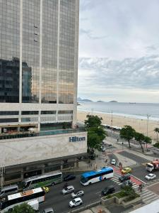 a busy city street with cars and buses in front of a hotel at COPACABANA RIO PRAIA 18 in Rio de Janeiro