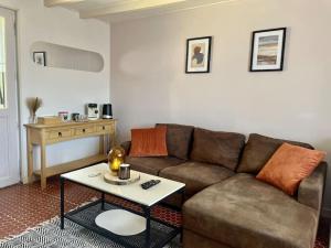 ein Wohnzimmer mit einem Sofa und einem Tisch in der Unterkunft Charmante maisonnette 