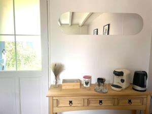 einen Holztisch in einer Küche mit Spiegel in der Unterkunft Charmante maisonnette 