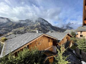 a wooden house with a mountain in the background at Chalet Nubuck - Pièces 134 in Saint-Martin-de-Belleville