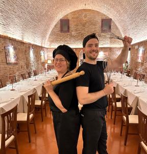 Um homem e uma mulher a segurar um taco de basebol. em Hotel Ristorante Borgo Antico em Monteroni dʼArbia