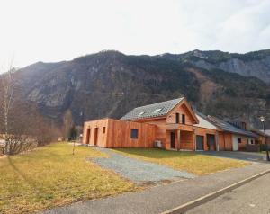 a wooden house with a mountain in the background at Oisans Chalet indépendant in Le Vert