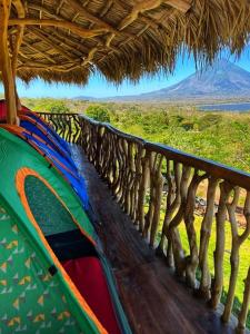 un bateau coloré assis sous un toit de paille dans l'établissement Hostel & Camping Sol Y Luna Ometepe, à Balgue