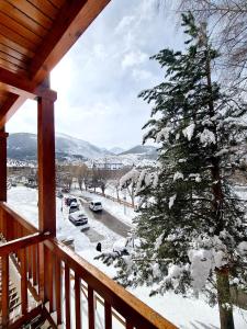 een veranda met uitzicht op een met sneeuw bedekte boom bij Encantador Apartamento en Pla de l’Ermita in Pla de l'Ermita