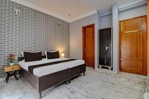 ein Schlafzimmer mit einem Bett und einer Ziegelwand in der Unterkunft OYO Hotel Galaxy?s Inn in Gurgaon