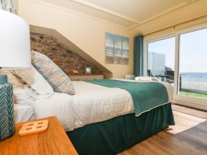 een slaapkamer met een groot bed en een groot raam bij Higher Mount View in Marazion