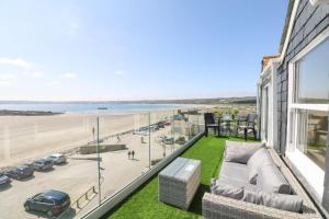 einen Balkon mit einem Sofa und Strandblick in der Unterkunft Higher Mount View in Marazion