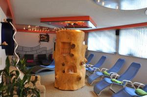 una sala de conferencias con sillas azules y un pilar de madera en Morgenfurt - Appartements 3 Sterne und Erdhäuser 4 Sterne in Alleinlage, en Weissensee