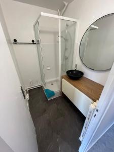 La salle de bains est pourvue d'un lavabo et d'un miroir. dans l'établissement Centre ville T2 - Aurillac - Parking Gratuit - Proche de la gare - 1 chambre - 1 canapé lit, à Aurillac