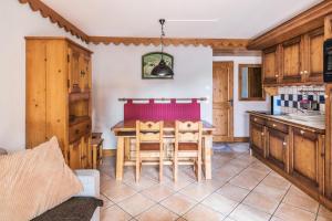 eine Küche mit einem Tisch und einigen Holzschränken in der Unterkunft Résidence Les Fermes du Soleil - maeva Home - Appartement 3 pièces 6 personnes Sélection MAE-1439 in Les Carroz d'Araches