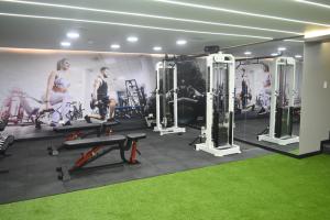 a gym with several machines and a green carpet at Hotel Veuxor in Machala