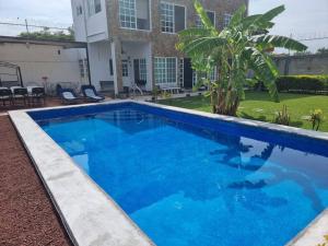 une piscine bleue en face d'une maison dans l'établissement Casa de Descanso en Familia TLAHUICA., à Los Limones