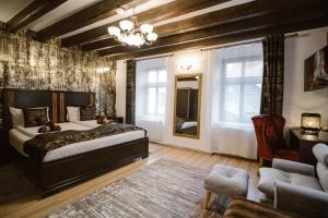 a bedroom with a bed and a couch and a chair at Hermannstadt House in Sibiu