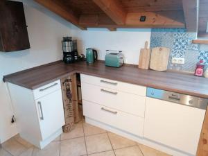 uma cozinha com armários brancos e um balcão de madeira em Ferienwohnung Lechsee em Lechbruck