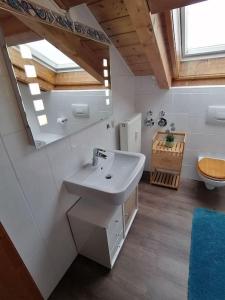 uma casa de banho com um lavatório e um WC em Ferienwohnung Lechsee em Lechbruck