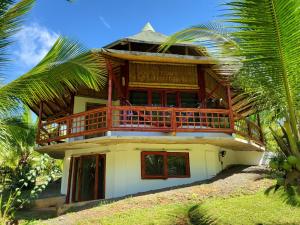 a house with a balcony on top of it at Eco-Lodge Deseo Bamboo in Santa Catalina