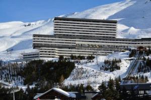 een groot gebouw bovenop een met sneeuw bedekte berg bij Résidence Cote Brune - Studio pour 4 Personnes 114 in Les Menuires