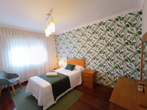 a bedroom with a bed and a wall mural at Apartamento Plaza in Caldas de Reis