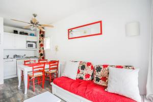 uma sala de estar com um sofá vermelho e uma mesa em Résidence Le Thabor - maeva Home - Appartement 2 pièces 5 personnes Confort 66 em Le Désert