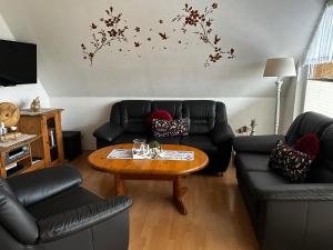 a living room with couches and a coffee table at Ferienwohnung Lara "Im Herzen von Ostfriesland" in Osteel