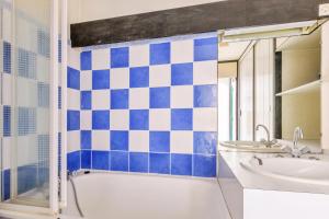ein Bad mit blau-weißen karierten Fliesen in der Unterkunft Studio avec accès direct aux pistes à la Mongie - Maeva Particuliers 86050 in La Mongie