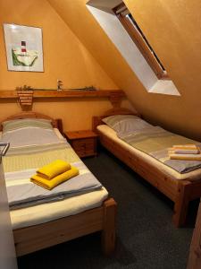 two twin beds in a room with an attic at Ferienwohnung Lara "Im Herzen von Ostfriesland" in Osteel