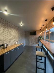 a kitchen with a long counter and a bar with stools at California in Khorodelets