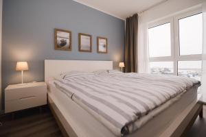 un letto bianco in una camera da letto con finestra di FeWo Backbord a Braunsbedra