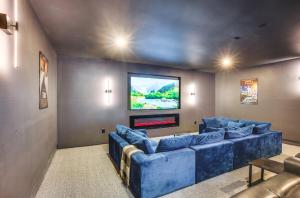 uma sala de estar com sofás azuis e uma televisão de ecrã plano em Gorgeous Conroe Getaway with Deck 6 Mi to Lake! em Conroe