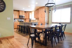 a large kitchen with a wooden table and chairs at 6 King Bedrooms, Sleeps 20, 8 Rooms, Bikes, HotTub in Lindon