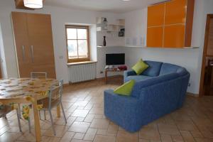 Maso de Propian في تيزيرو: غرفة معيشة مع أريكة زرقاء وطاولة