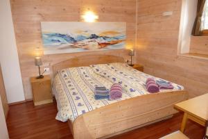 um quarto com uma cama e uma parede de madeira em Maso de Propian em Tesero