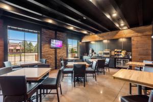 a restaurant with tables and chairs and a bar at Cobblestone Hotel & Suites - Lynden in Lynden