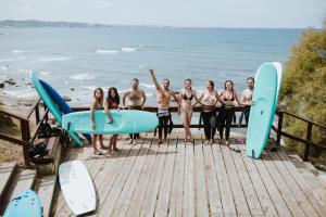 希洪的住宿－Gijon Surf Hostel，一群人站在一个有冲浪板的码头上