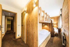 una camera con letto a castello e pareti in legno di Résidence Les Chalets du Forum - maeva Home - Appartement 2 pièces 6 person 30 a Courchevel