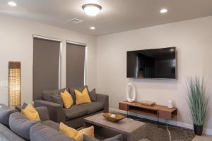 uma sala de estar com um sofá e uma televisão em Solara Escape em St. George