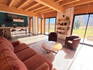 a living room with a couch and a table at Oisans Chalet indépendant in Le Vert