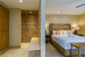 a bedroom with a bed and a walk in shower at El Noa Noa in Palm Springs