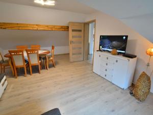 a living room with a television and a table and chairs at Holiday home 200 qm Kolobrzeg in Kołobrzeg