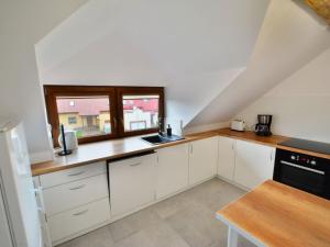 a kitchen with white cabinets and a window at Holiday home 200 qm Kolobrzeg in Kołobrzeg