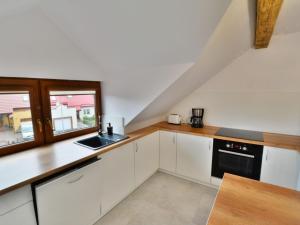 a kitchen with white cabinets and a sink and a window at Holiday home 200 qm Kolobrzeg in Kołobrzeg