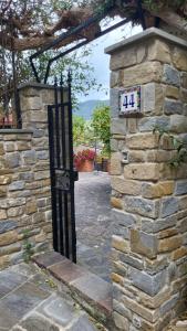 a gate in a stone wall with a sign on it at Casa Del Fico in Montecorice